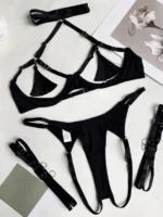 Black 3 piece cut out lingerie set with tassel bra, thong, and adjustable leg garters flat lay